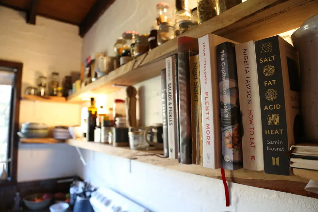 Sydney bookshelf with various books, jars, and cups in the sydney property